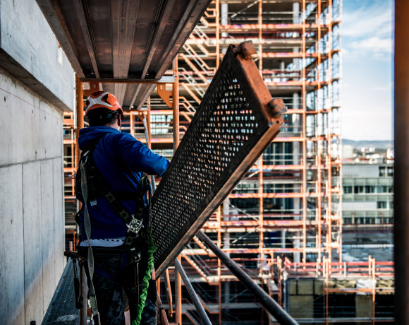 Man working on a building wearing fall protection equipment