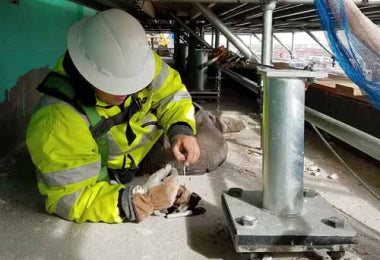 Construction worker examining a tie-back anchor
